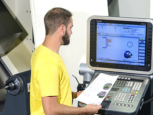 An employee works on a special machine for tool and mould making